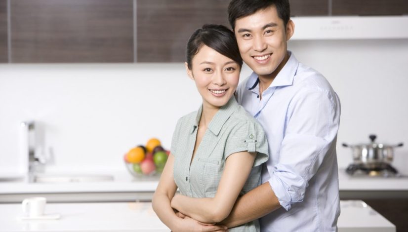 Portrait of Chinese couple arm around in the kitchen