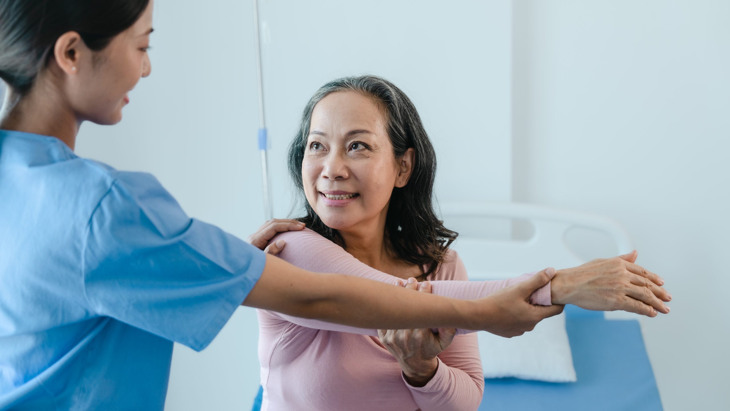 Asian Chinese female physiotherapist caregiver helping elderly w