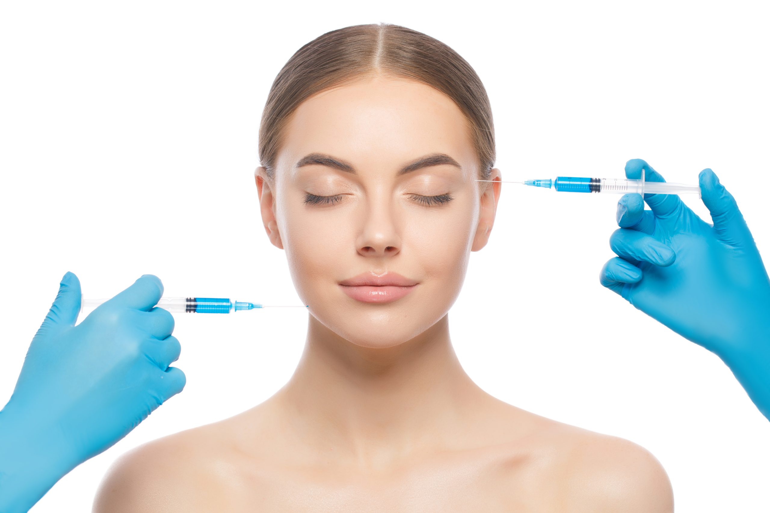 Attractive young woman stands with closed eyes ready for face injection by doctor