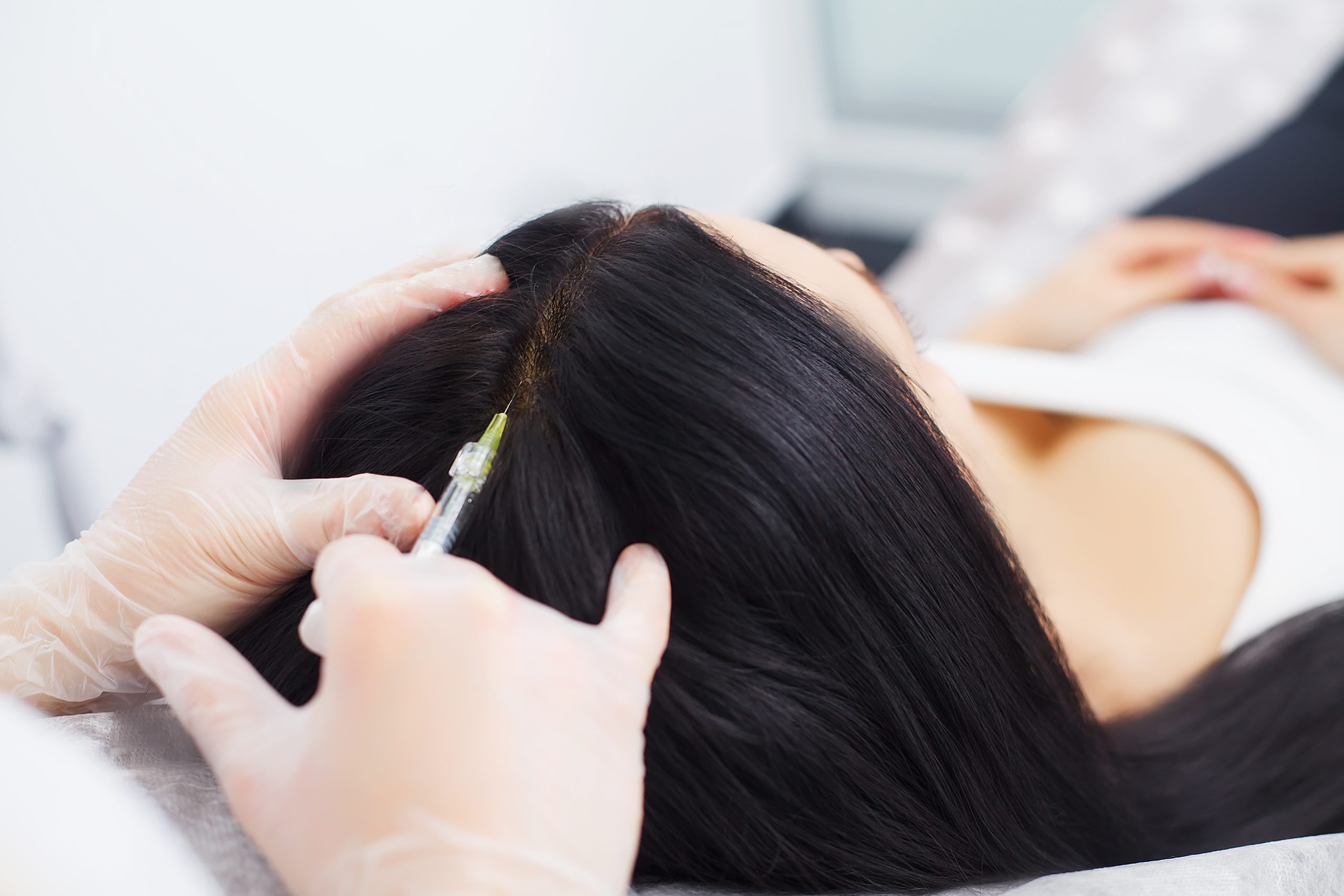 Closeup of Beautiful young woman gets injection in eye and lips area from beautician. preservation of beauty concept