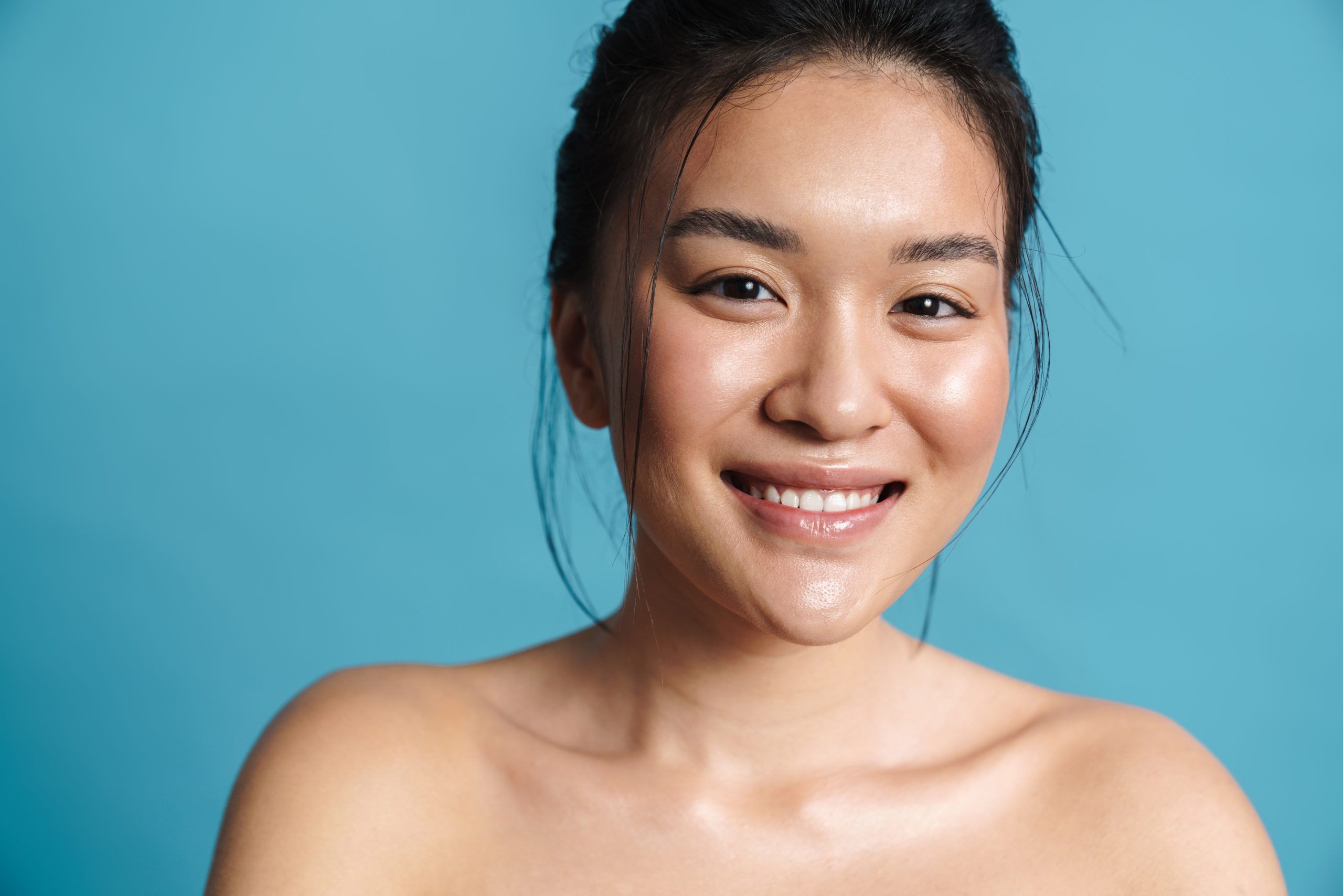Image of shirtless asian girl smiling and looking at camera