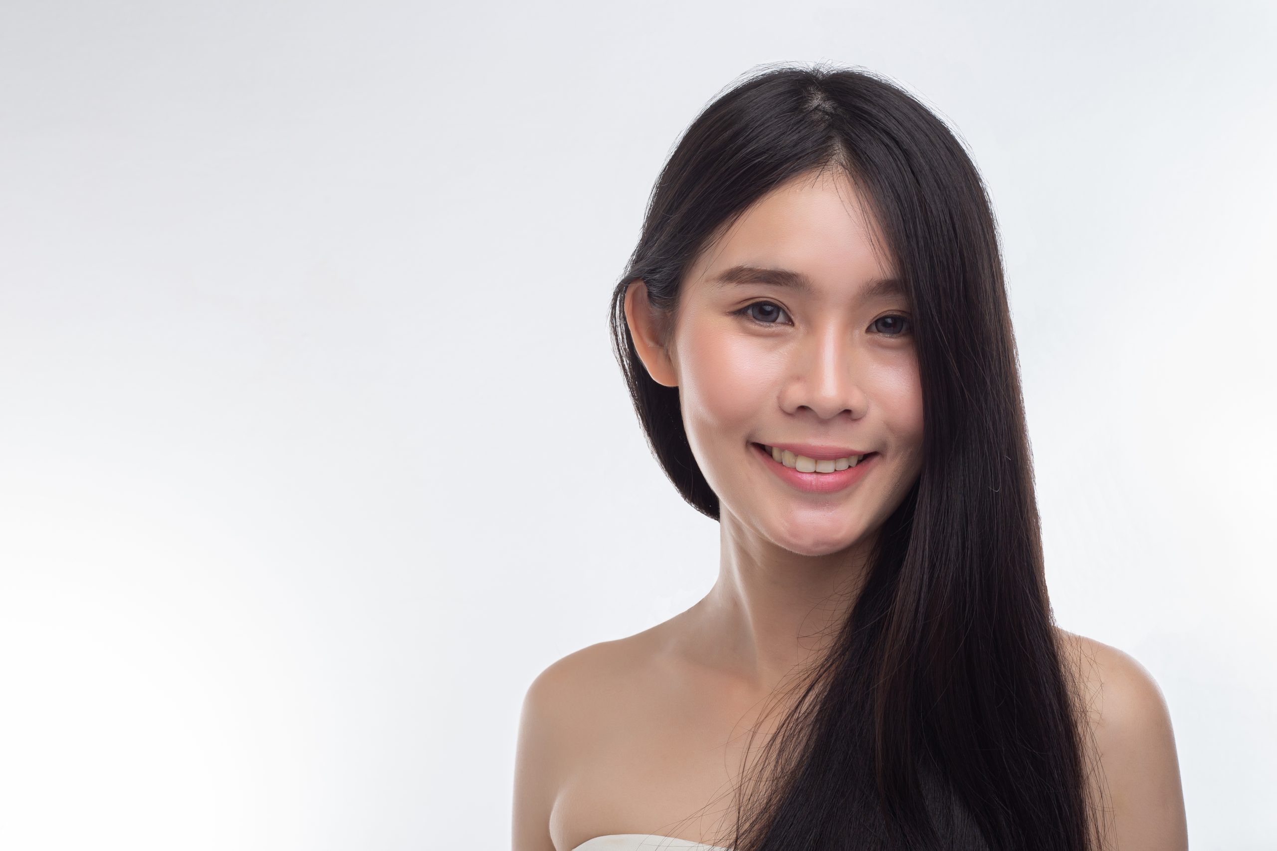 The woman wore a white strapless dress and smiled happily.